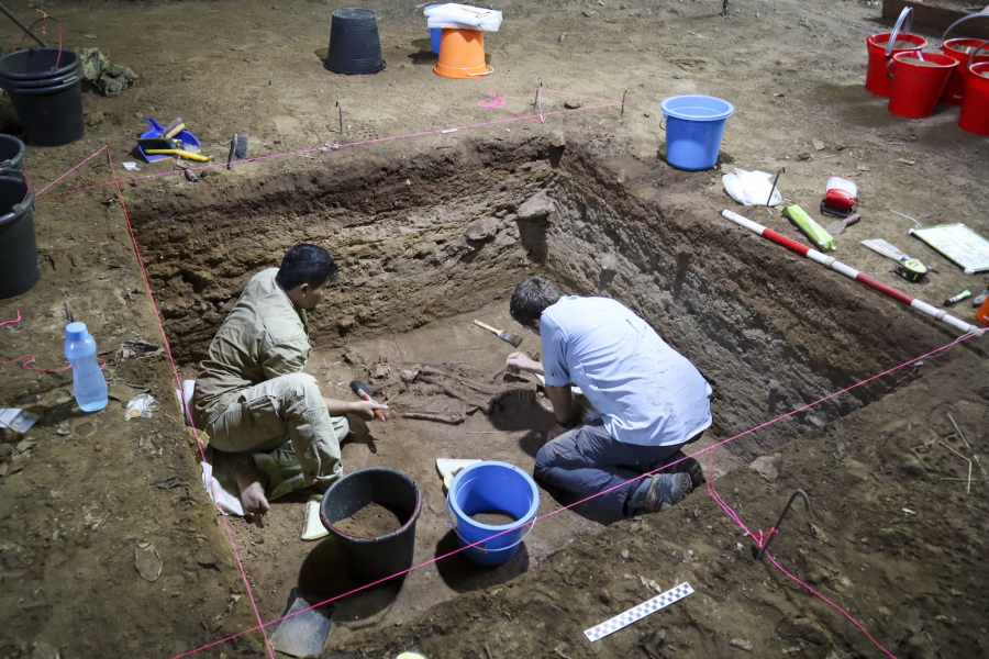 Dr. Tim Maloney and Andika Priyatno work at the site in a cave March 2, 2020, in East Kalimantan, Borneo, Indonesia. The remains, which have been dated to 31,000 years old, mark the oldest evidence for amputation yet discovered.