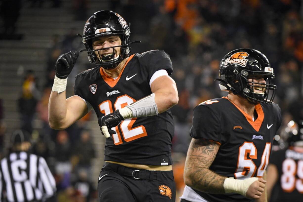 FILE - Oregon State linebacker Jack Colletto (12) and offensive lineman Nathan Eldridge (64) celebrate Colleto's touchdown in the fourth quarter of an NCAA college football game against Arizona State, Saturday, Nov. 20, 2021, in Corvallis, Ore. Turns out Colletto can do a lot of different things. He's a rare two-way player for the Beavers, playing both at inside linebacker and at running back. Even sometimes at receiver.