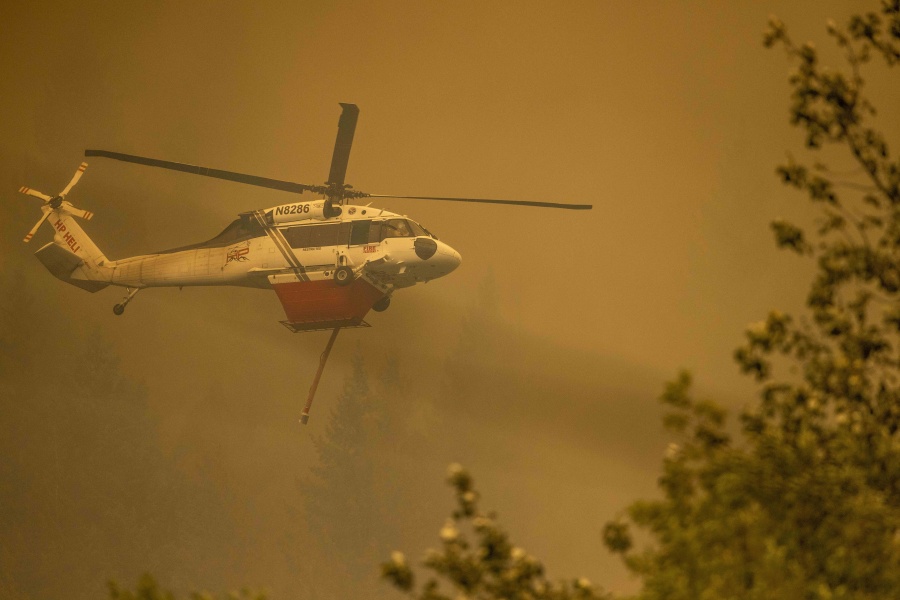 A helicopter provides air support for fighting the Bolt Creek Fire in Washington state on Saturday, Sept. 10, 2022.
