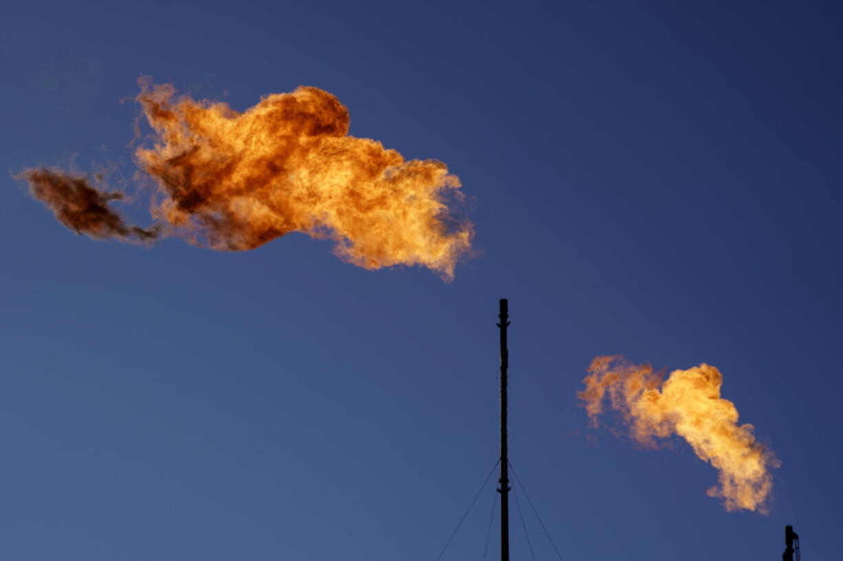 FILE - Flares burn off methane and other hydrocarbons at an oil and gas facility in Lenorah, Texas, Friday, Oct. 15, 2021. Climate scientists have found that methane emissions from the oil and gas industry are far worse than what companies are reporting, despite claims by some major firms that they've reduced their emissions.