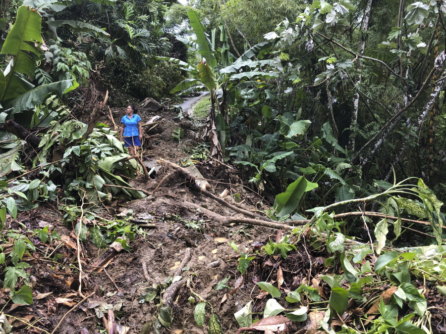 Nancy Galarza looks at the damage that Hurricane Fiona inflicted on her community, which remained cut off four days after the Category 1 storm slammed the rural community of San Salvador in the town of Caguas, Puerto Rico, on Thursday.