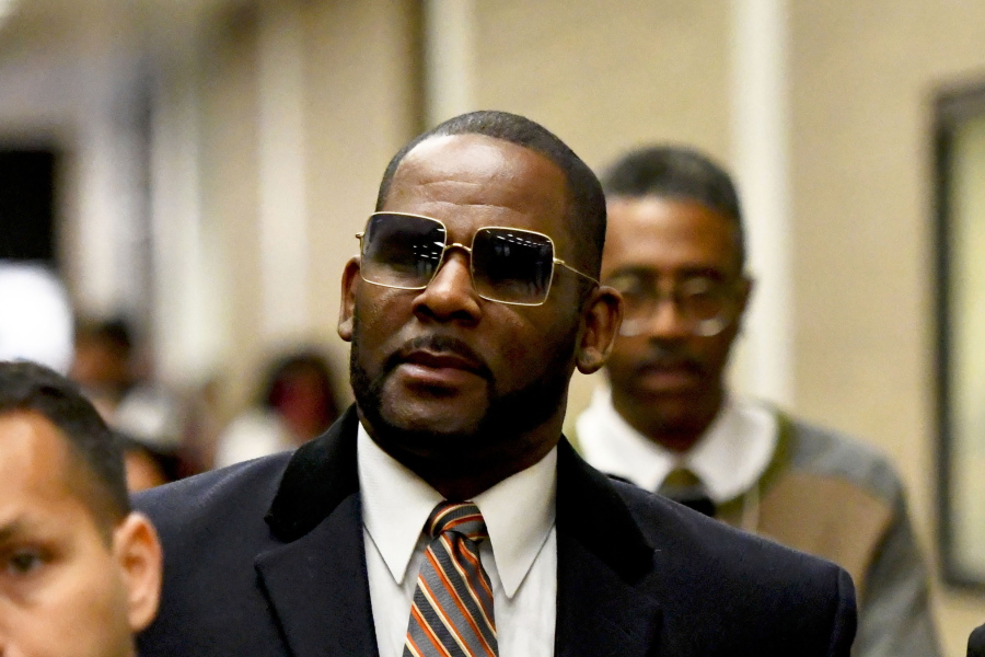 FILE - Musician R. Kelly, center, leaves the Daley Center after a hearing in his child support case on May 8, 2019, in Chicago. Closing arguments are scheduled Monday, Sept. 12, 2022 for R. Kelly and two co-defendants in the R&B singer's trial on federal charges of trial-fixing, child pornography and enticing minors for sex, with jury deliberations to follow.