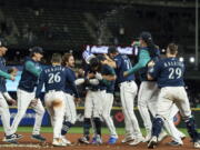 Seattle Mariners, including Adam Frazier (26), J.P. Crawford, center, Chris Flexen (77), Luis Castillo, second from right, and Cal Raleigh, right, celebrate after a single by Crawford in the 11th inning drove in the winning run in a baseball game against the Texas Rangers, Thursday, Sept. 29, 2022, in Seattle. The Mariners won 10-9.