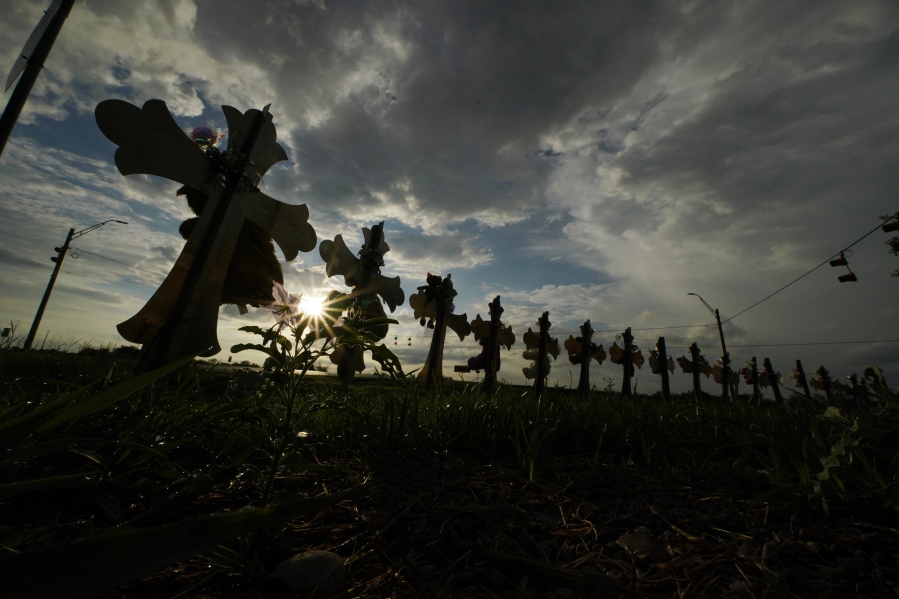 FILE - Vehicles pass crosses placed to honor the victims of the shootings at Robb Elementary School, Thursday, Aug. 25, 2022, in Uvalde, Texas. An Associated Press analysis found many U.S. states barely use the red flag laws touted as the most powerful tool to stop gun violence before it happens, a trend blamed on a lack of awareness of the laws and resistance by some authorities to enforce them even as shootings and gun deaths soar.