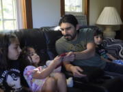 Mohammad Walizada, center right, who fled Afghanistan with his family, sits with three of his children, from the left, Zahra, 10, Hasnat, 3, and Mohammad Ibrahim, 7, Thursday, Sept. 15, 2022, at their home, in Epping, N.H. Since the U.S. military's withdrawal from Kabul last year, the Sponsor Circle Program for Afghans has helped over 600 Afghans restart their lives in their communities. Now the Biden administration is preparing to turn the experiment into a private-sponsorship program for refugees admitted through the U.S. Refugee Admissions Program and is asking organizations to team up with it to launch a pilot program by the end of 2022.