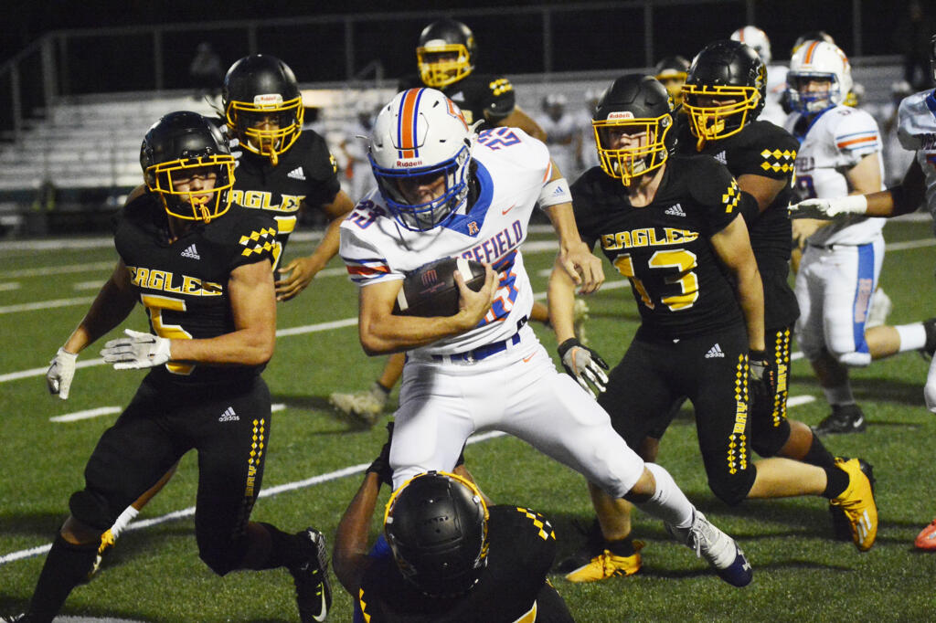 Ridgefield’s Rocco Wright (23) runs over a Hudson’s Bay tackler during the first half of a 2A Greater St. Helens League football game at Kiggins Bowl on Thursday, Sept. 22, 2022.