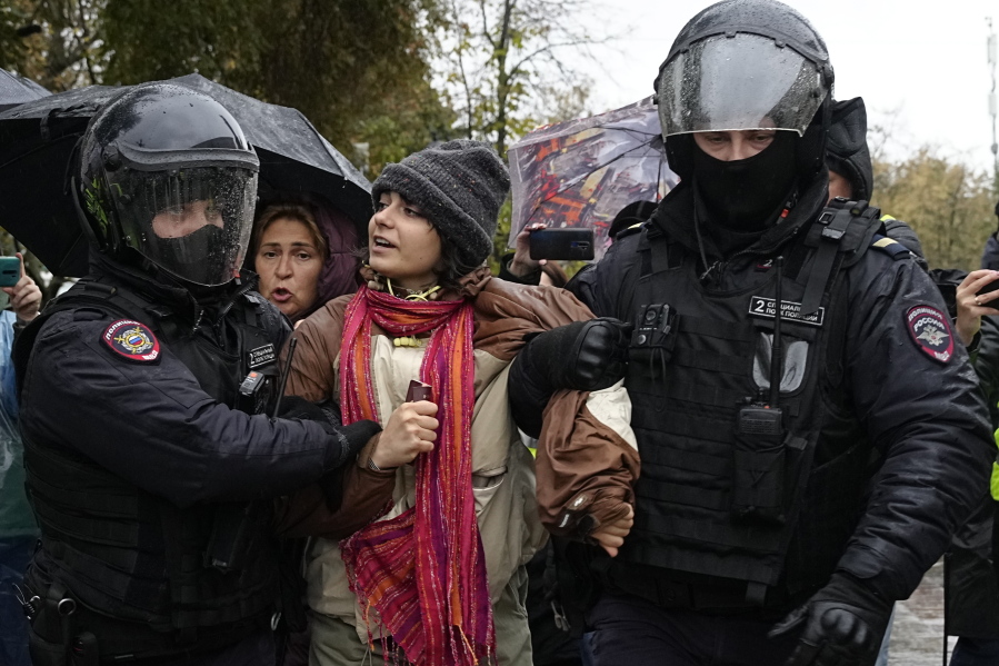 Police officers detain a demonstrator during a protest against a partial mobilization in Moscow, Russia, Saturday, Sept. 24, 2022.