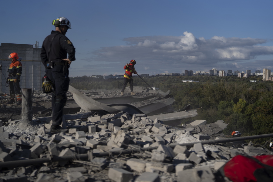 Members of the rescue service work to clean the debris and unstable structures that could fall, on the roof of a residential building that was damaged after a Russian attack in Kharkiv, Ukraine, Wednesday, Sept. 21, 2022.