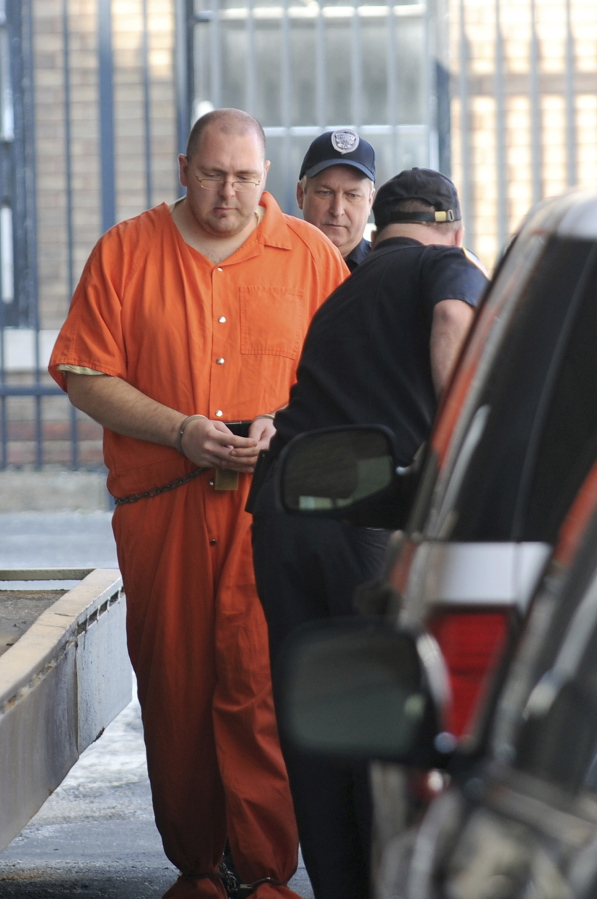 FILE - Michael Carneal, 27, is escorted by a guard from the U.S. District Courthouse in Paducah, Ky., March 18, 2011. Carneal pleaded guilty in 1998 to killing three students and injuring five others in 1997 at Heath High School, when he was 14.