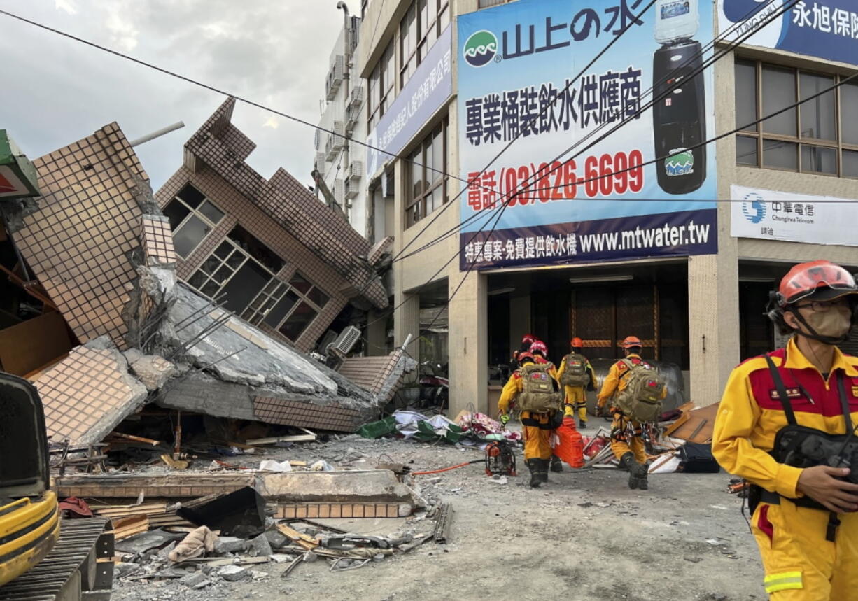 This photo provided by Hualien County fire department show firefighters in the search for trapped victims in a collapsed residential building following earthquake in Yuli township in Hualien County, eastern Taiwan, Sunday, Sept. 18, 2022.