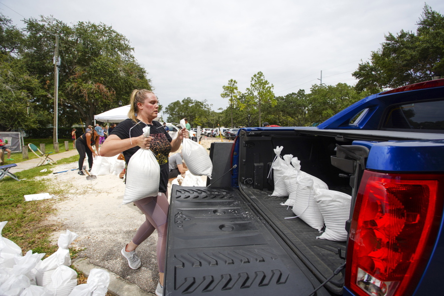 Victoria Colson, 31, of Tampa loads sandbags into her truck along with other Tampa residents who waited for over 2 hours at Himes Avenue Complex to fill their 10 free sandbags on Sunday, Sept. 25, 2022, in Tampa, Fla.