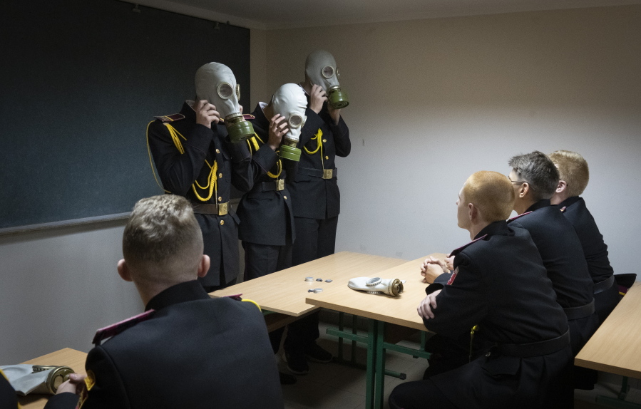 Cadets practice an emergency situation during a lesson in a bomb shelter on the first day of school at a cadet lyceum in Kyiv, Ukraine, Thursday, Sept. 1, 2022.