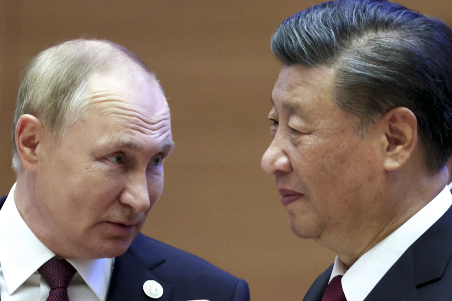 Russian President Vladimir Putin, left, speaks to Chinese President Xi Jinping during the Shanghai Cooperation Organization (SCO) summit in Samarkand, Uzbekistan, Friday, Sept. 16, 2022.