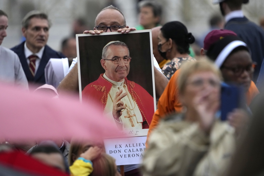 A man holds a photo of Pope John Paul I during the beatification ceremony led by Pope Francis in St. Peter's Square at the Vatican.