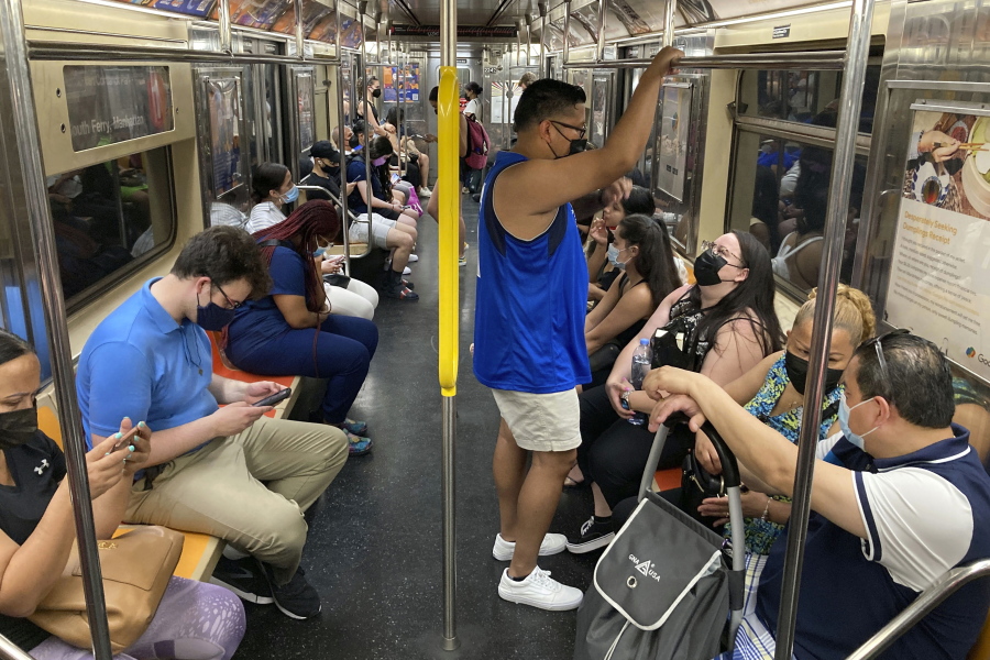 FILE -- Commuters wear face masks while riding the subway in New York, June 6, 2021. New York state is dropping its mask requirement on public transportation thanks in part to the availability of new booster shots targeting the most common strain of COVID-19, Gov. Kathy Hochul announced Wednesday, Sept. 7, 2022.