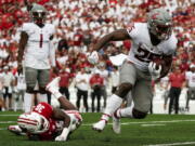Washington State's Nakia Watson (25) runs past Wisconsin's Jake Chaney (36) during the first half of an NCAA college football game Saturday, Sept. 10, 2022, in Madison, Wis.