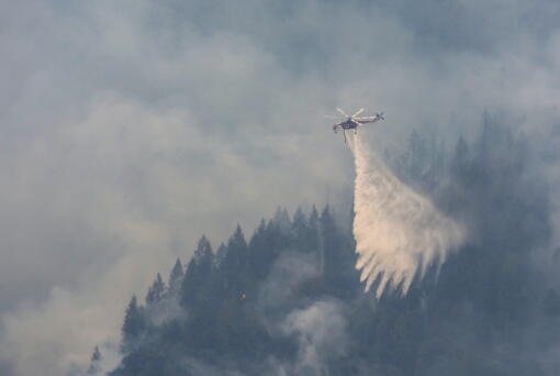 A Sikorsky S-64 "Skycrane" drops water on a ridge near Baltimore Mine Road during the Mosquito Fire on Sunday, Sept. 11, 2022. The Mosquito Fire has grown to 78 square miles (200 square kilometers), with 18% containment, according to the California Department of Forestry and Fire Protection.