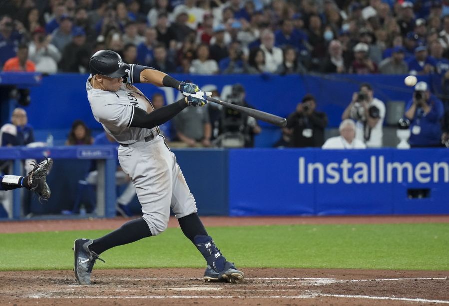 New York Yankees' Aaron Judge hits a two-run home run, his 61st homer of the season, during the seventh inning of the team's baseball game against the Toronto Blue Jays on Wednesday, Sept. 28, 2022, in Toronto.