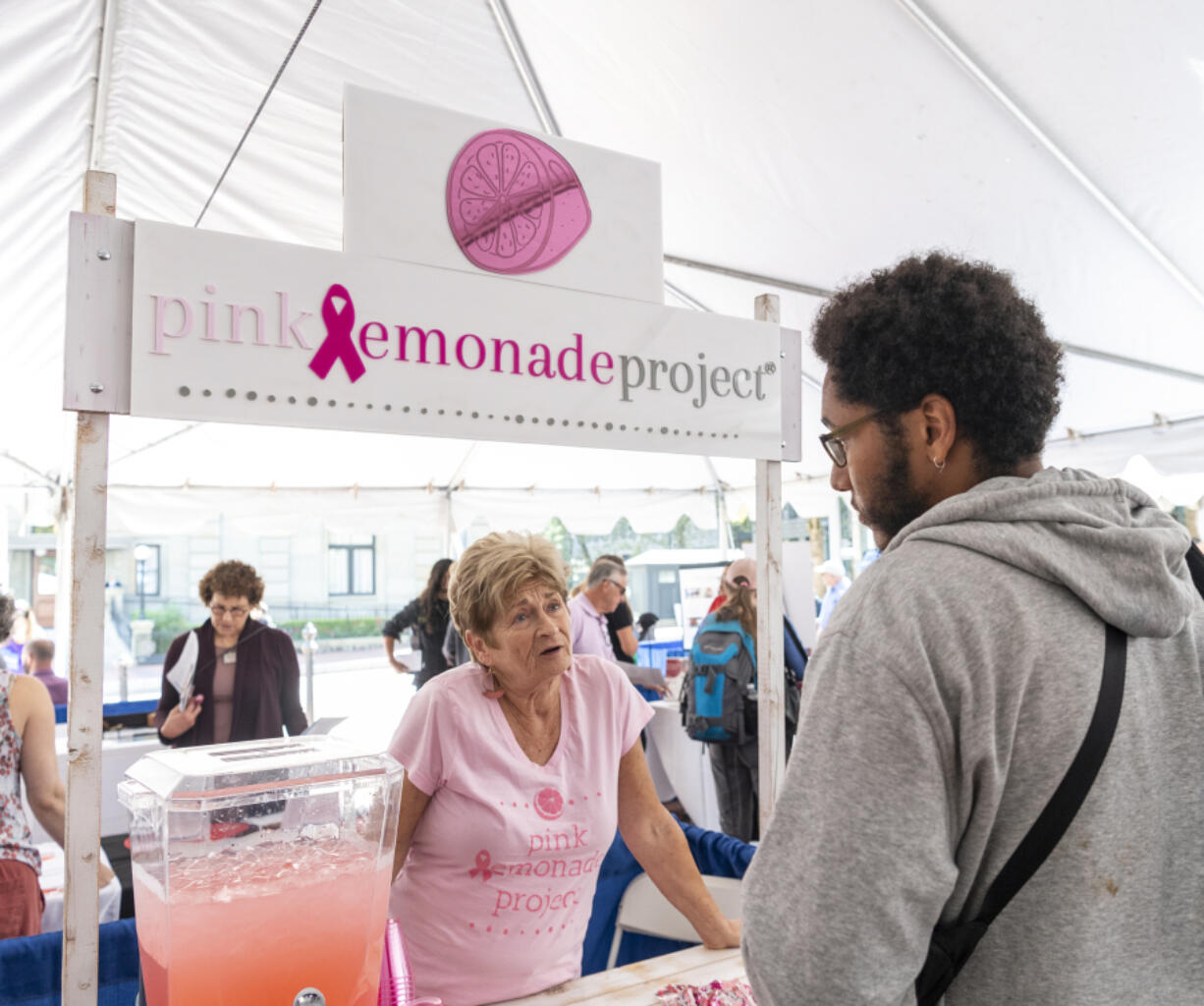 Pink Lemonade Project Girlfriends coordinator Linda Aronsohn, left, talks to Zachary Maina of Portland on Sept. 8 at The Standard Volunteer Expo at Pioneer Courthouse Square in Portland. The nonprofit took over many programs formerly managed by Susan G. Komen's Portland-based chapter when the national nonprofit consolidated operations.