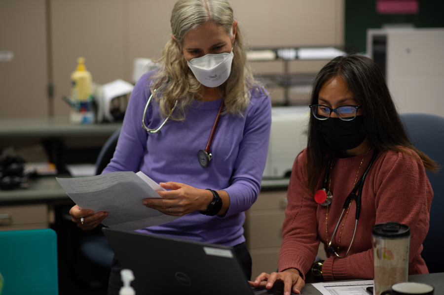 Lea Gutierrez, clinic supervisor, at right, and Deb Brown, physician assistant, discuss a patient's case on Sept. 28 at the Free Clinic of Southwest Washington. The clinic, on Plomondon Road, offers free health care for those without insurance and advocacy for those with limited English language skills.