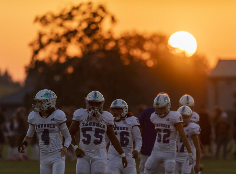 The sun sets over Mountain View players as they warm up Friday, Oct. 7, 2022, during a game between Prairie and Mountain View at District Stadium in Battle Ground.