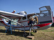 Jay Bell, left, aircraft-restoration specialist for the Western Antique Aeroplane & Automobile Museum, works on a 1947 Republic RC-3 Seabee as Sally Runyan hops out of the aircraft with her dog, Luke, at Green Mountain Airport on Oct. 11. Runyan donated the aircraft to the museum in Hood River, Ore. She has gradually been letting go of planes restored by her late husband, Ben Runyan, who died in a 2008 plane crash.