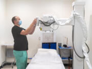 Physician assistant and Vital Care owner Todd Cichosz adjusts an X-ray machine at the new primary and urgent care clinic in Battle Ground.