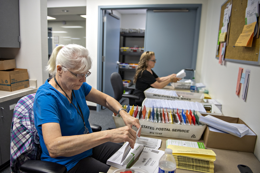 Election workers Juanita Berry, left, and Valerie Vance gear up for the upcoming election at the Clark County Elections Office on Thursday afternoon. Ballots were due to be mailed Friday to approximately 325,000 registered voters.