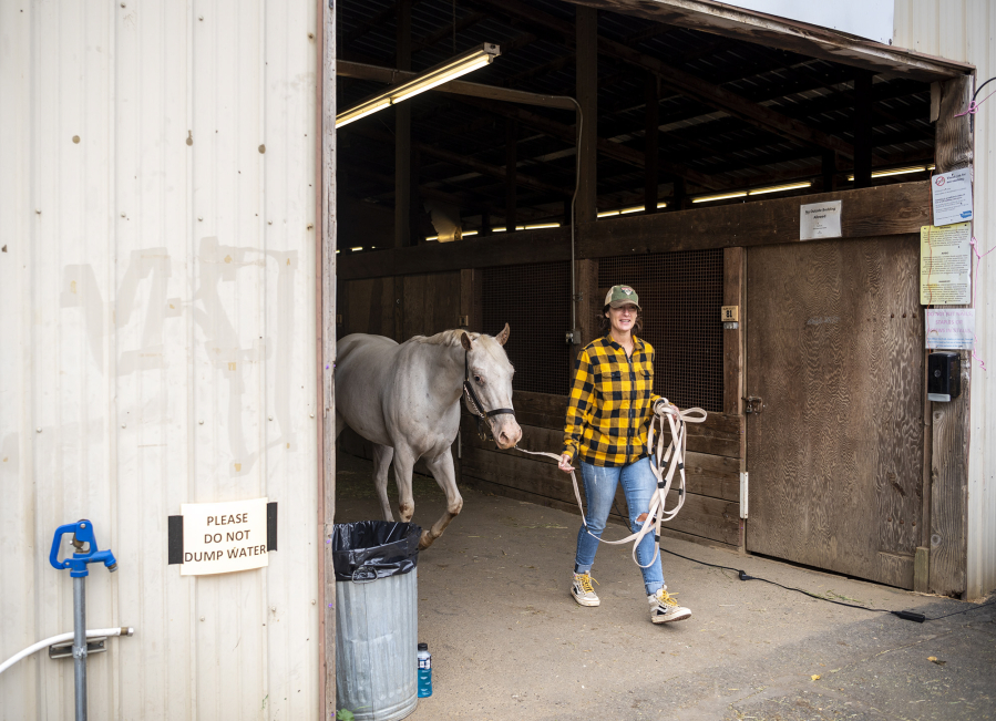 Koreen Concannon of Camas walks 7-year-old horse Leah out of the stables on Monday at the fairgrounds. Evacuees like Concannon were able to bring horses to the Fairgrounds stables.