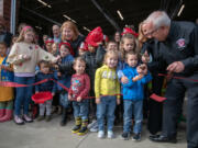 Local children help Vancouver and Clark County officials cut the ceremonial ribbon at Saturday's grand opening for the city's new Fire Station 11.