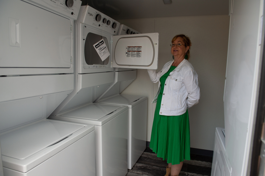 Friends of the Carpenter Board President Wendy Wright displays a dryer in a new laundry trailer at the organization's west Vancouver workshop. The washers and dryers will be open to those in need for free use as soon they're connected to electricity.
