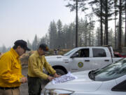 Marcus Kaufmann, left, and Tyler Arbogast of the Oregon Department of Forestry look over a map of the Nakia Fire area at Jones Creek Trailhead on Wednesday afternoon, Oct. 19, 2022.