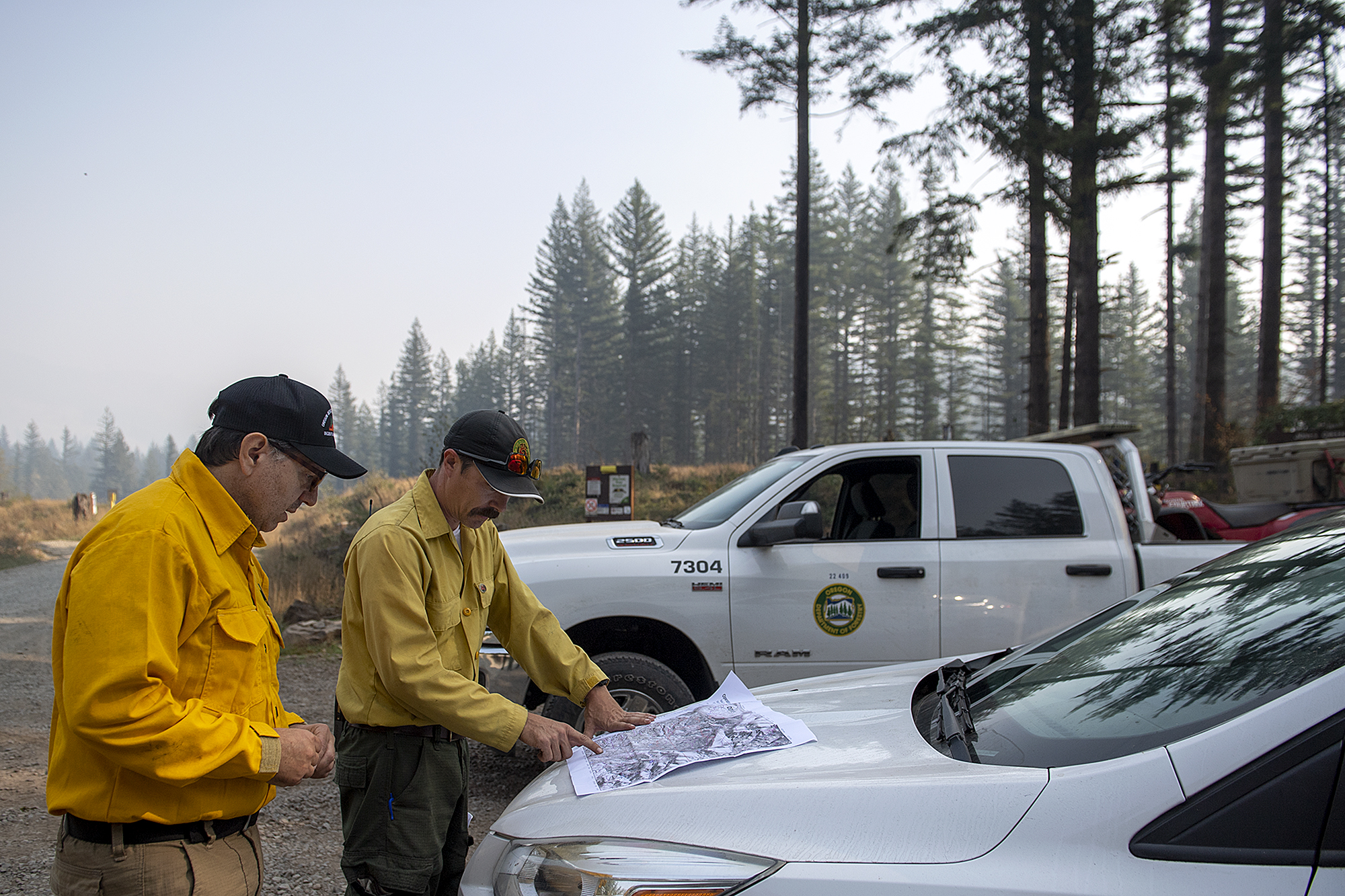 Marcus Kaufmann, left, and Tyler Arbogast of the Oregon Department of Forestry look over a map of the Nakia Fire area at Jones Creek Trailhead on Wednesday afternoon, Oct. 19, 2022.