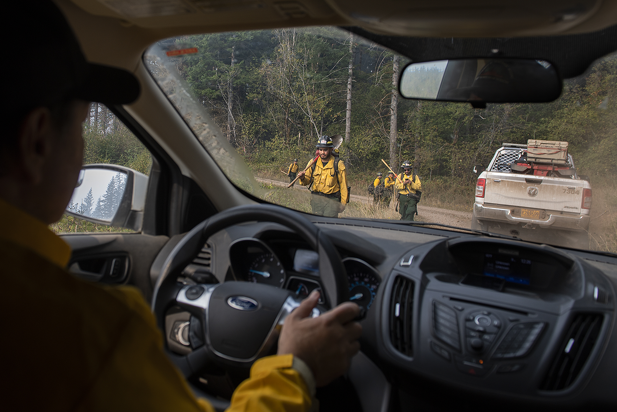 Marcus Kauffman of the Oregon Department of Forestry, left, passes fire crews as they work at the Nakia Fire on Wednesday afternoon, Oct. 19, 2022.