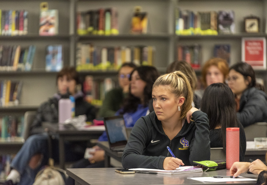 Columbia River senior Sophie Worden listens to candidates speak and takes notes Tuesday during a local candidate forum at Columbia River High School.