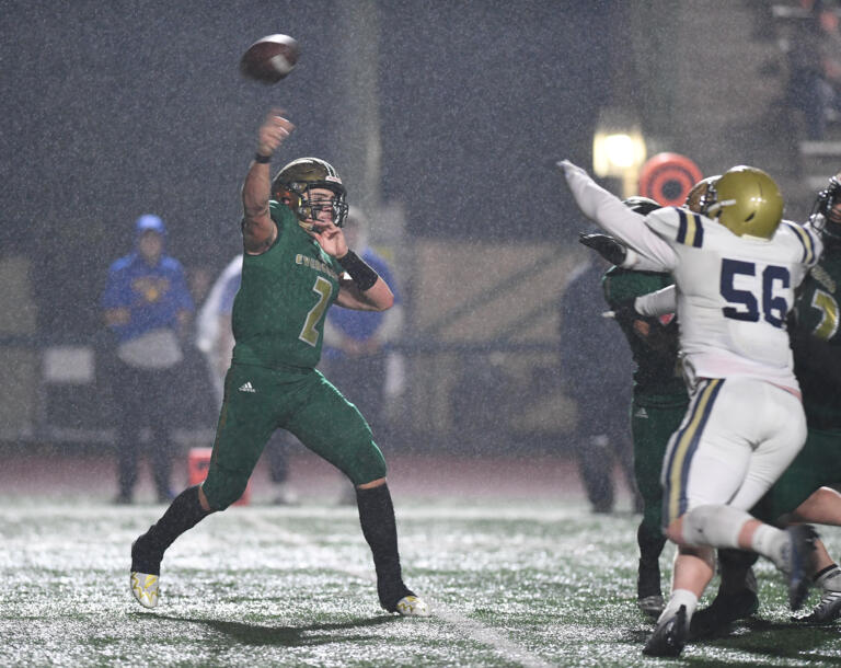 Rain drenches the field as Evergreen junior Jayden Crace, left, throws the ball Friday, Oct. 28, 2022, during a game between Kelso and Evergreen at McKenzie Stadium.