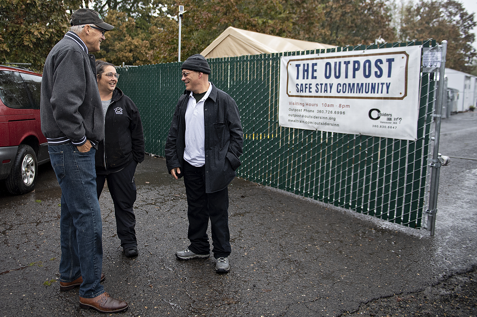 Gov. Jay Inslee, from left, talks with Jamie Spinelli, Vancouver’s Homeless Response Coordinator, and Adam Kravitz, executive director of Outsiders Inn, at the conclusion of his tour of the Outpost Safe Stay Community on Monday morning, Oct. 31, 2022.
