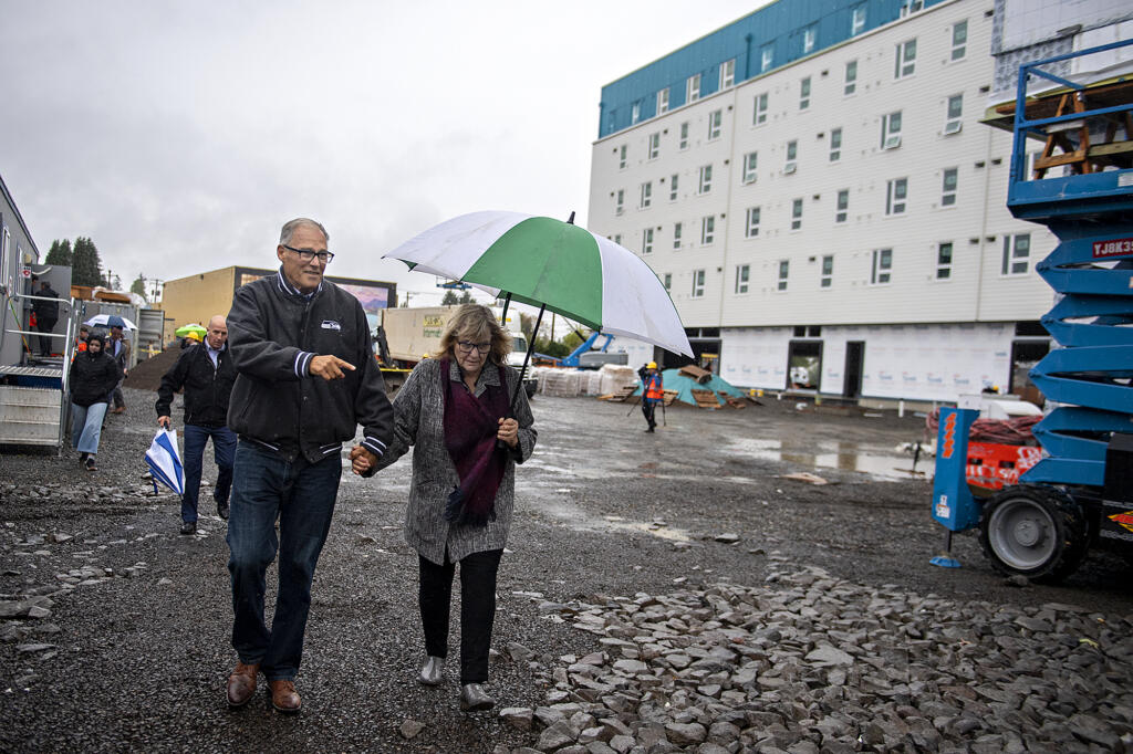 Gov. Jay Inslee, left, and his wife, Trudi, leave after joining a tour of the Fourth Plain Community Commons mixed-use building project on Monday morning, Oct. 31, 2022.