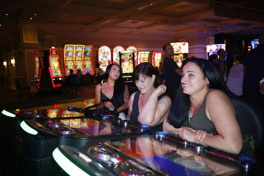 Stacey McLachlan, right, of Vancouver, plays an electronic table game at the Bellagio on Oct. 6, 2022, in Las Vegas, with her mother Sharon, middle, and their friend Ciara Tabb, left.