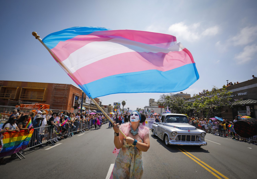 Sister Yesate of the Sisters of Perpetual Indulgence waves a transgender flag while walking the annual San Diego Pride Parade in March 2021.