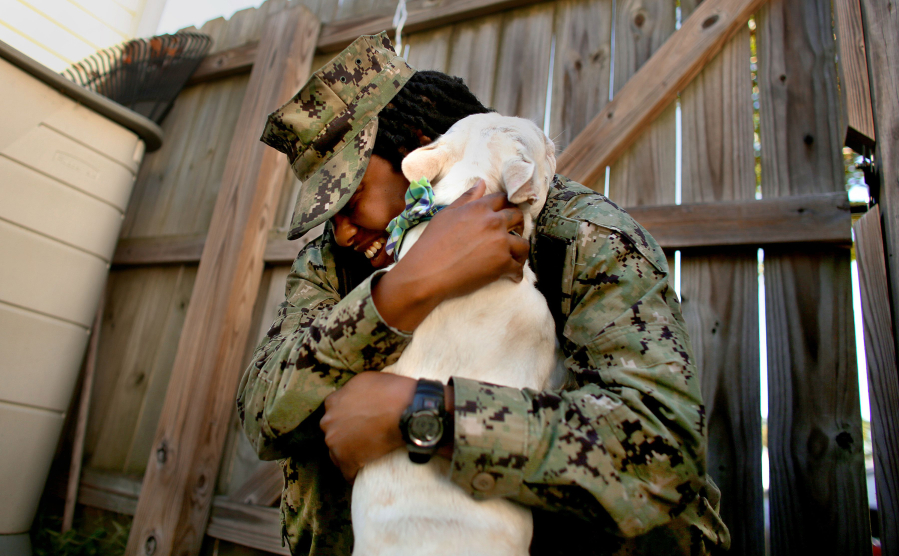 After being apart for over a year, Petty Officer 2nd Class Myesha Harris, who was deployed on the USS Harry S. Truman, and her 21/2-year-old male French bulldog Nipsey are reunited Oct. 14 in Deb Coon's backyard. (Stephen M.