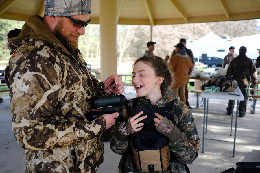 Corinne Holmes, 9, right, laughs with her father, Josh Holmes, as they prepare to head out on an evening hunt during a spring turkey camp on April 22, 2022, near Colville, Washington.