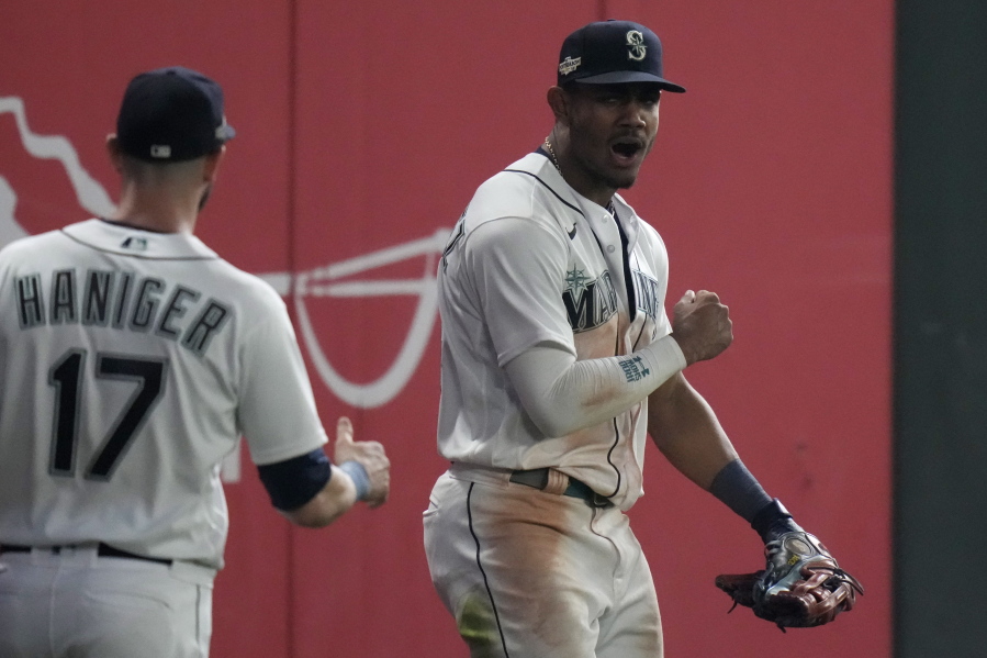 Seattle Mariners center fielder Julio Rodriguez, right, celebrates after making a catch for an out against the Houston Astros, during the 16 inning in Game 3 of an American League Division Series baseball game Saturday, Oct. 15, 2022, in Seattle.