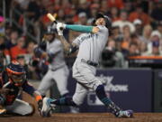 Seattle Mariners' J.P. Crawford loses his helmet on a strikle swing during the ninth inning in Game 2 of an American League Division Series baseball game against the Houston Astros in Houston, Thursday, Oct. 13, 2022. (AP Photo/David J.