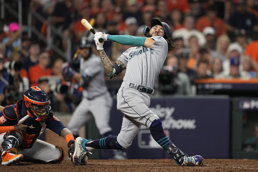 Seattle Mariners' J.P. Crawford loses his helmet on a strikle swing during the ninth inning in Game 2 of an American League Division Series baseball game against the Houston Astros in Houston, Thursday, Oct. 13, 2022. (AP Photo/David J.
