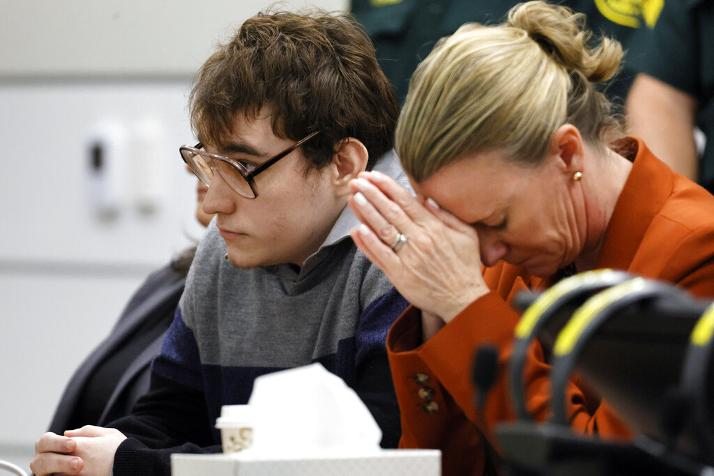Assistant public defender Melisa McNeill, seated with Marjory Stoneman Douglas High School shooter Nikolas Cruz touches her hands to her head as the last of the 17 verdicts were read in the penalty phase of Cruz's trial at the Broward County Courthouse in Fort Lauderdale, Fla., on Thursday, Oct. 13, 2022.  Cruz will be sentenced to life without parole for the 2018 massacre of 17 people at Parkland’s Marjory Stoneman Douglas High School. That sentence comes after the jury announced Thursday that it could not unanimously agree that Cruz should be executed.