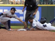 Seattle Mariners' Julio Rodriguez (44) slides safely into second base for a double under Houston Astros second baseman Jose Altuve during the eighth inning in Game 3 of an American League Division Series baseball game Saturday, Oct. 15, 2022, in Seattle. (AP Photo/Ted S.