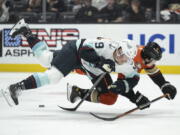 Seattle Kraken center Ryan Donato (9) and Anaheim Ducks defenseman Jamie Drysdale (6) trip while vying for the puck during the first period of an NHL hockey game in Anaheim, Calif., Wednesday, Oct. 12, 2022.