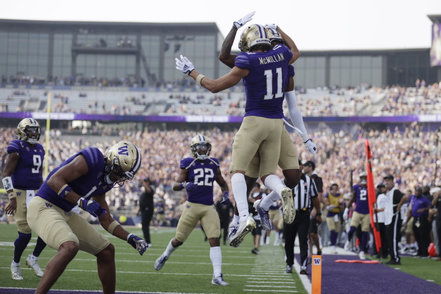 Washington wide receiver Jalen McMillan (11) leaps in the air as he celebrates his touchdown with other team members against Arizona during the first half of an NCAA football game, Saturday, Oct. 15, 2022, in Seattle.