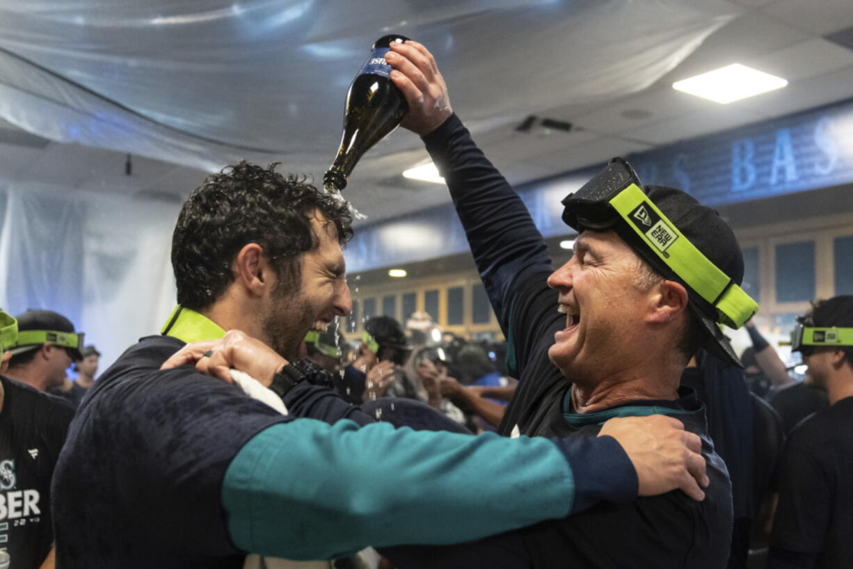 Seattle Mariners manager Scott Servais, right, celebrates in the clubhouse after the team's baseball game against the Oakland Athletics, Friday, Sept. 30, 2022, in Seattle. The Mariners won 2-1 to clinch a spot in the playoffs.